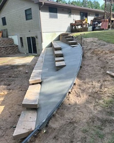 Curved concrete steps poured beside a sloped backyard in Wilson, NC