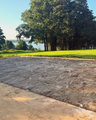 Dark stamped concrete slab with a lake view in Wilson, NC