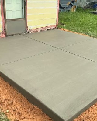 Concrete slab with saw cut joints at the back door of a yellow home in Wilson, NC