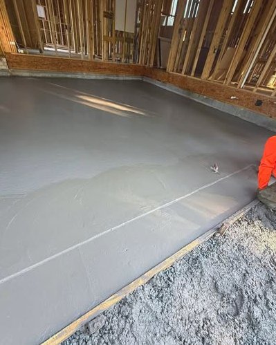 Concrete slab floor being troweled inside a framed building in Wilson, NC