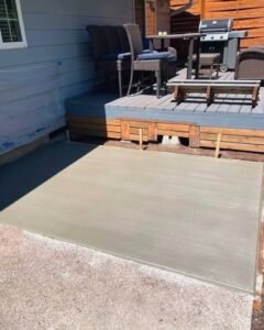 Gray concrete patio slab beside a wood deck with a grill in Wilson, NC