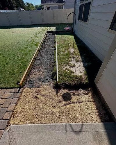 Gravel and sand base with forms prepared for a concrete slab beside a house in Wilson, NC