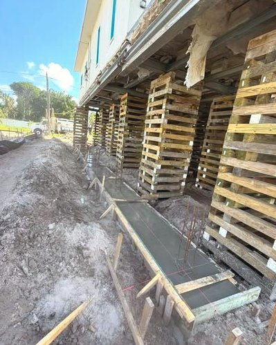 Concrete footing with rebar under an elevated home on pallets in Wilson, NC