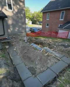 Concrete footing forms and excavation between two houses in Wilson, NC