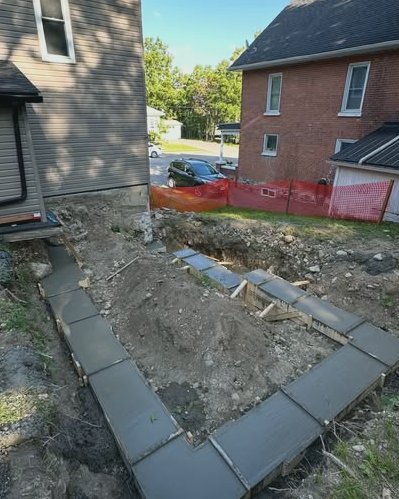 Concrete footing forms and excavation between two houses in Wilson, NC