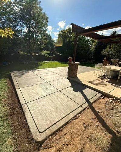 Gray stamped concrete patio with a pergola in Wilson, NC