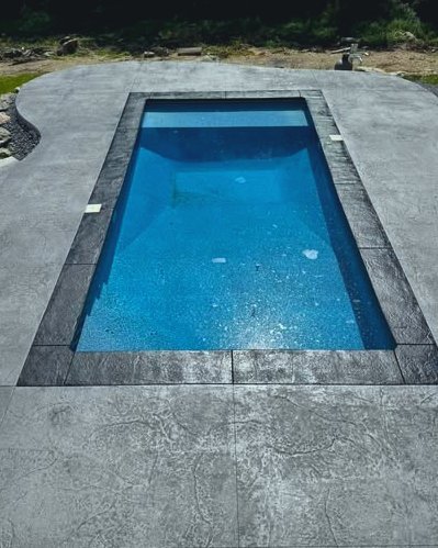 Gray stamped concrete pool deck around a blue pool in Wilson, NC