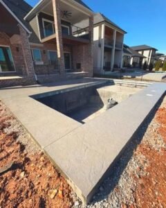Stamped concrete pool deck under construction at a brick house in Wilson, NC